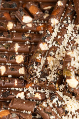 Pieces of broken organic milk chocolate with nuts and raisins. Healthy sweets