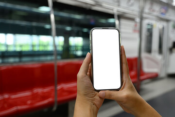 Hands holding a smartphone with blank screen in city subway