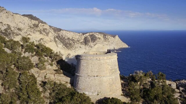 Ibiza&rsquo;s Torre des Savinar and Mediterranean Coastline &ndash; Aerial Closeup of Historic Tower and Scenic Shores in Deep Blue Waters &ndash; Drone Orbiting