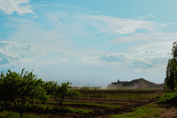 Khor Virap Monastery sits on a hillside, overlooking Armenias fertile fields and clouds