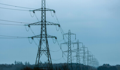 Electricity Pylons Tower Above And Stretch Across The Landscape Of The United Kingdom