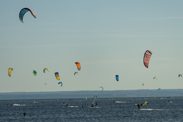 People swim on the sea on a kiteboard or kitesurfing. Kitesurfing lessons on the bay. Summer sport...