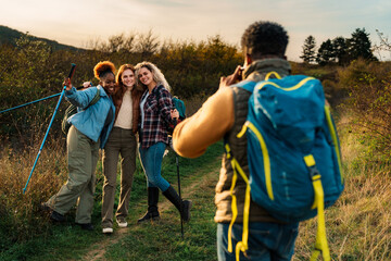Smiling group of diverse hikers posing for a photo on a trail.