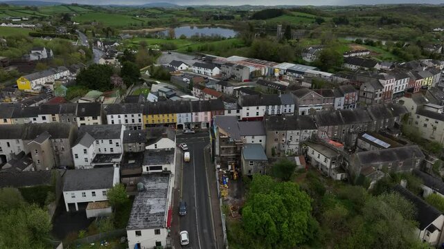 Ballybay Town, County Monaghan, Ireland, April 2024. Drone orbits clockwise descending towards the Main Street intersection with residential houses and the picturesque Lough Major in the distance.