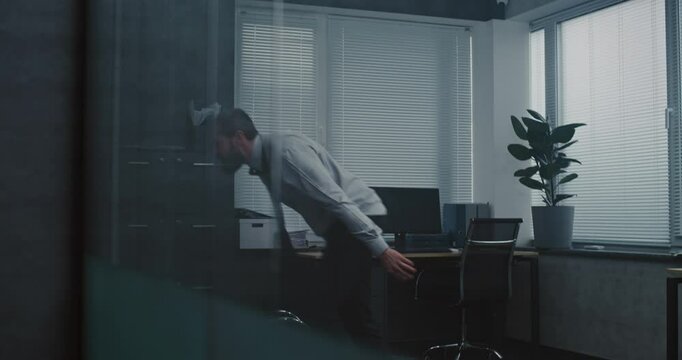 Aggressive businessman loses his temper in a fit of rage. Furious and angry male office employee throws things and papers off the shelf, yells and destroys office room. Financial crisis or dismissal.