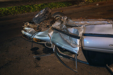 Severe damage to the car. Night accident. Close-up. The car turned over on the road. Close-up....