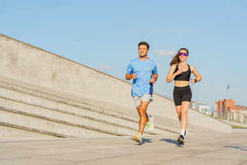 Fitness Enthusiasts Jog Together on a Sunny Day Near Urban Architecture While Enjoying Their Workout