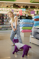 Little girl pulling nasty toy dog at pet shop