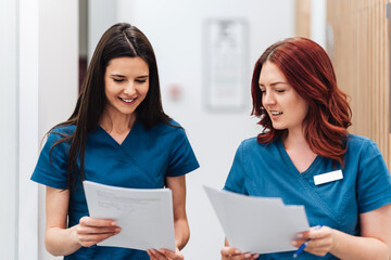 Two beautiful and serious female doctors or a technicians standing in a modern clinic for diagnosis...