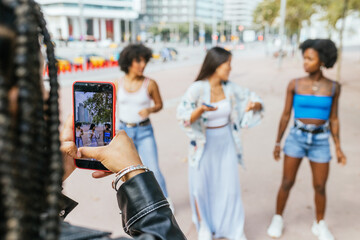 Woman recording friends dancing in urban environment
