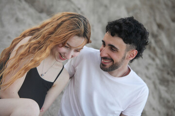 closeup portrait of a young cheerful loving couple sitting outdoors talking