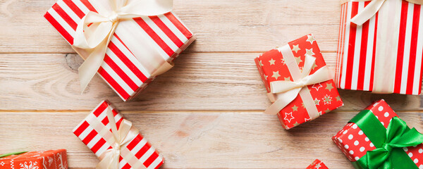 Obraz premium A lot of Christmas gift boxes in colored paper decorated on table, Top view close up. Many present New Year gift