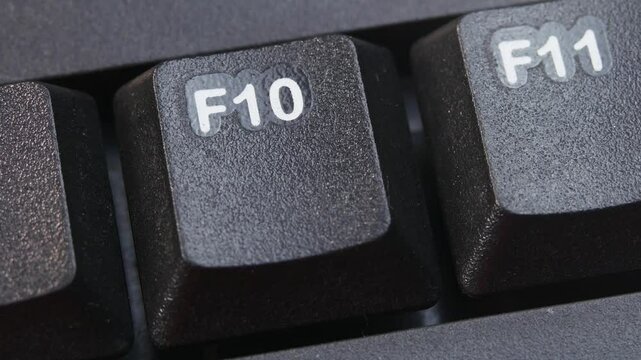 F10 or F Ten Key on Desktop Keyboard Pressed by Finger Hand Multiple Times - Close Up Macro Shot