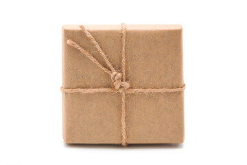 Gift box wrapped in eco craft paper with jute bow isolated on white background with copy space. Top view.	