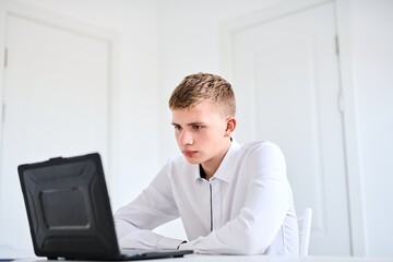Fototapeta premium Portrait of high school student in white uniform with laptop, distance online learning