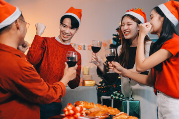 Group of young Asian man and women as friends having fun at a New Year's celebration, holding gift...