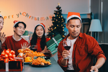Group of young Asian man and women as friends having fun at a New Year's celebration, holding gift...