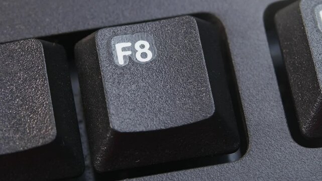F8 or F Eight Key on Desktop Keyboard Pressed by Finger Hand Multiple Times - Close Up Macro Shot