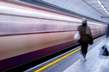 A Passing High Speed Passenger Train Flying Past A Train Station Platform