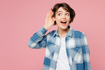 Young curious nosy woman she wear blue shirt white t-shirt casual clothes try to hear you overhear listening intently isolated on plain pastel light pink background studio portrait. Lifestyle concept.