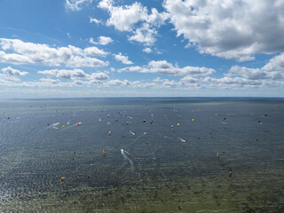 People swim on the sea on a kiteboard or kitesurfing. Kitesurfing lessons on the bay. Summer sport...
