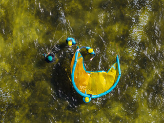 People swim on the sea on a kiteboard or kitesurfing. Kitesurfing lessons on the bay. Summer sport...