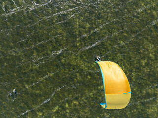 People swim on the sea on a kiteboard or kitesurfing. Kitesurfing lessons on the bay. Summer sport...