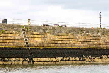 A Harbour Wall Ladder Giving Access To And From The Waters Below