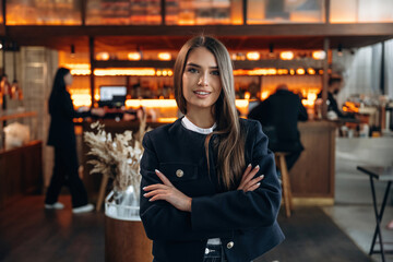 People are behind at background. Restaurant owner or manager is standing indoors