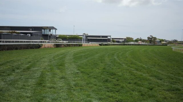 Pan over horse race track with green grass