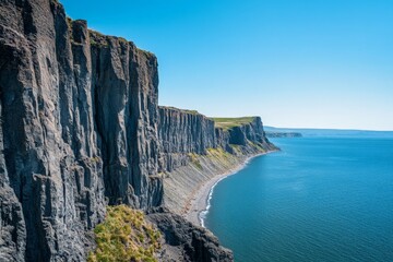 A breathtaking view of majestic cliffs meeting the vast ocean under clear blue skies, showcasing nature's raw beauty and serene coastal landscapes.