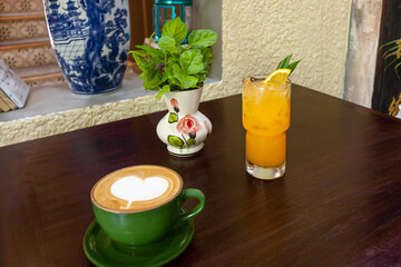 A Green Plant between a Blue Ceramic Vase and a Yellow Orange Juice Giving the idea of a Secondary Color between Two Primary Colors