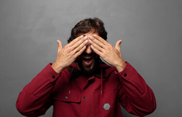 smiling and feeling happy, covering eyes with both hands and waiting for unbelievable surprise