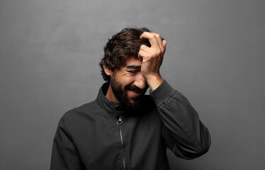 Fototapeta premium laughing and slapping forehead like saying d’oh! I forgot or that was a stupid mistake