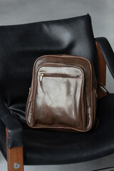 Brown leather backpack on the stylish chair