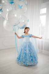little girl in blue dress with giant helium balloons
