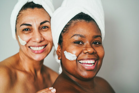 Multiracial senior and young women doing beauty treatment using skin masks - Body care concept - Focus on african woman eye