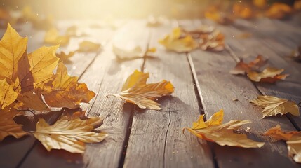 Golden and orange autumn leaves scattered across a wooden surface, with warm sunlight filtering through, evoking the cozy and rustic feel of fall