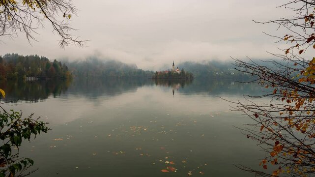 Lake Bled in Slovenia. Time lapse video in a rainy day with scenic panoramic autumn view of the church on the Island Bled in the Julian Alps in Slovenia.