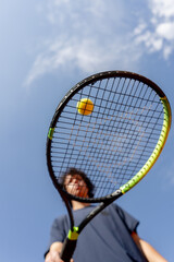 low shot close up professional tennis court young curly guy trains hitting the ball with tennis racket professional preparation for the game