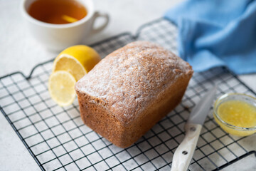 Whole pound cake decorated with powdered sugar on a cooling rack