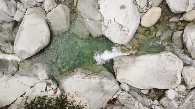 Top down aerial of serene waterfalls in Corsica, water passing through granite