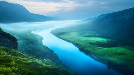 Fototapeta premium Enchanting Glowing River Winding Through Lush,Misty Valley with Distant Mountains
