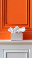 A white gift box with tissue paper sits on a mantelpiece