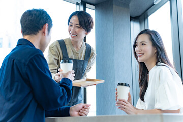 お客様に飲み物を渡す女性店員