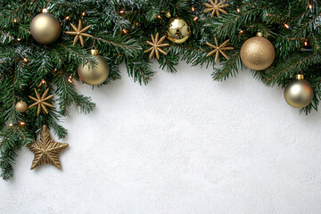 A festive arrangement of green pine branches decorated with golden ornaments and stars framing a white background creating a holiday feel
