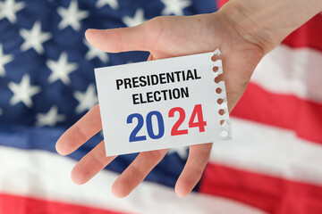 Politics and voting concept. Presidential election 2024 text on white paper over the American flag...