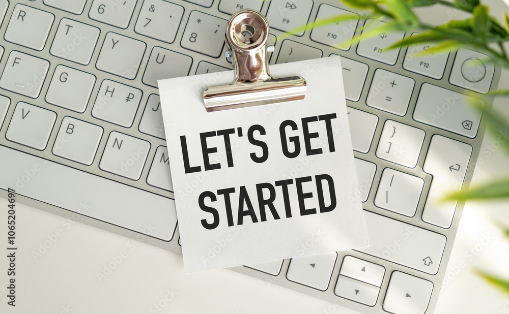 Poster let's get started- text written on sticky note lying on the keyboard with office background