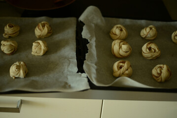 homamde cinnamon buns rising on a baking sheet, 