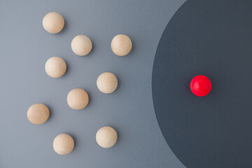 Abstract red ball stays in the safe zone while the other wood balls are outside the area, comfort...